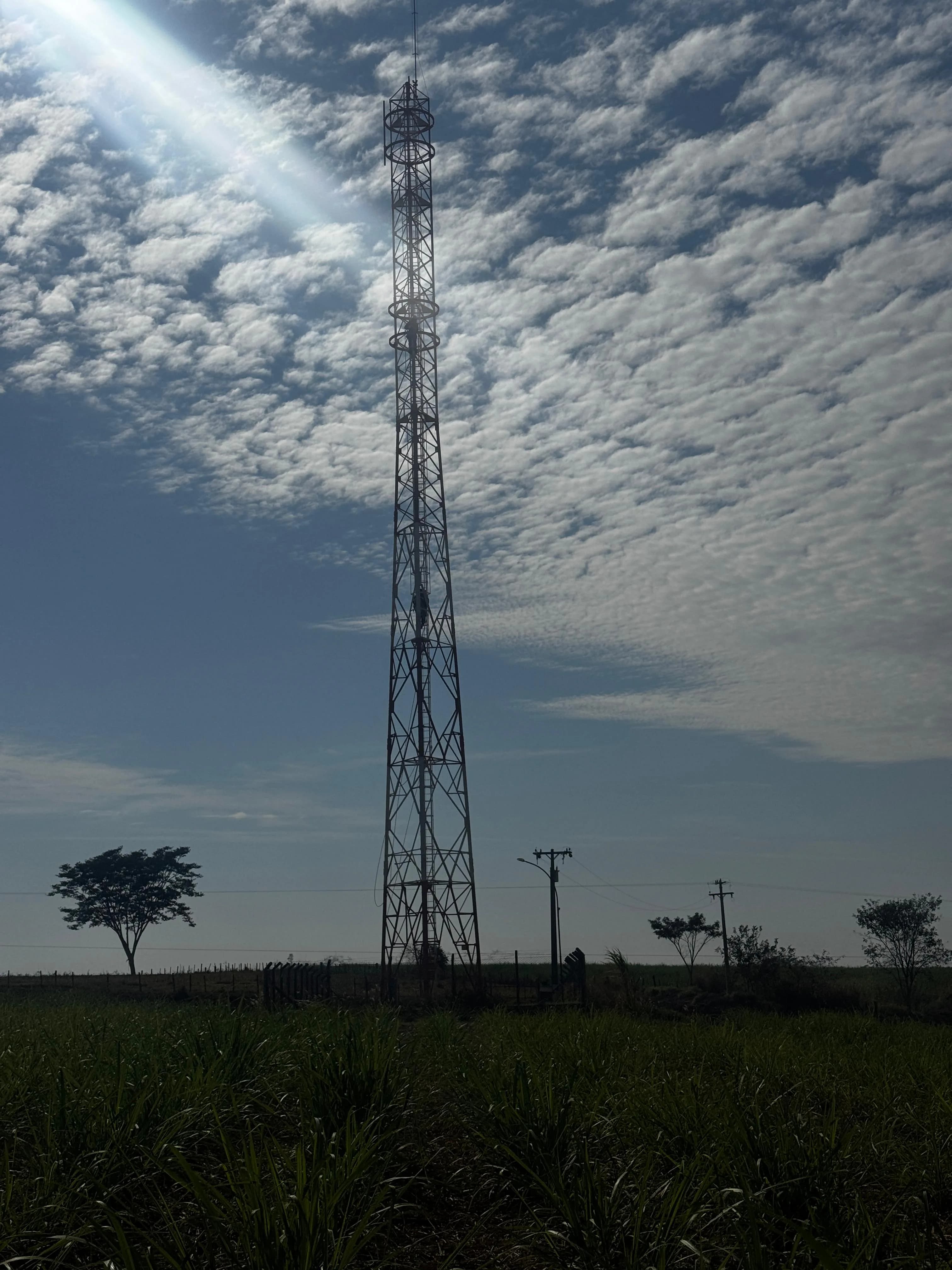 Torre de telecom instalada em campo sob céu aberto