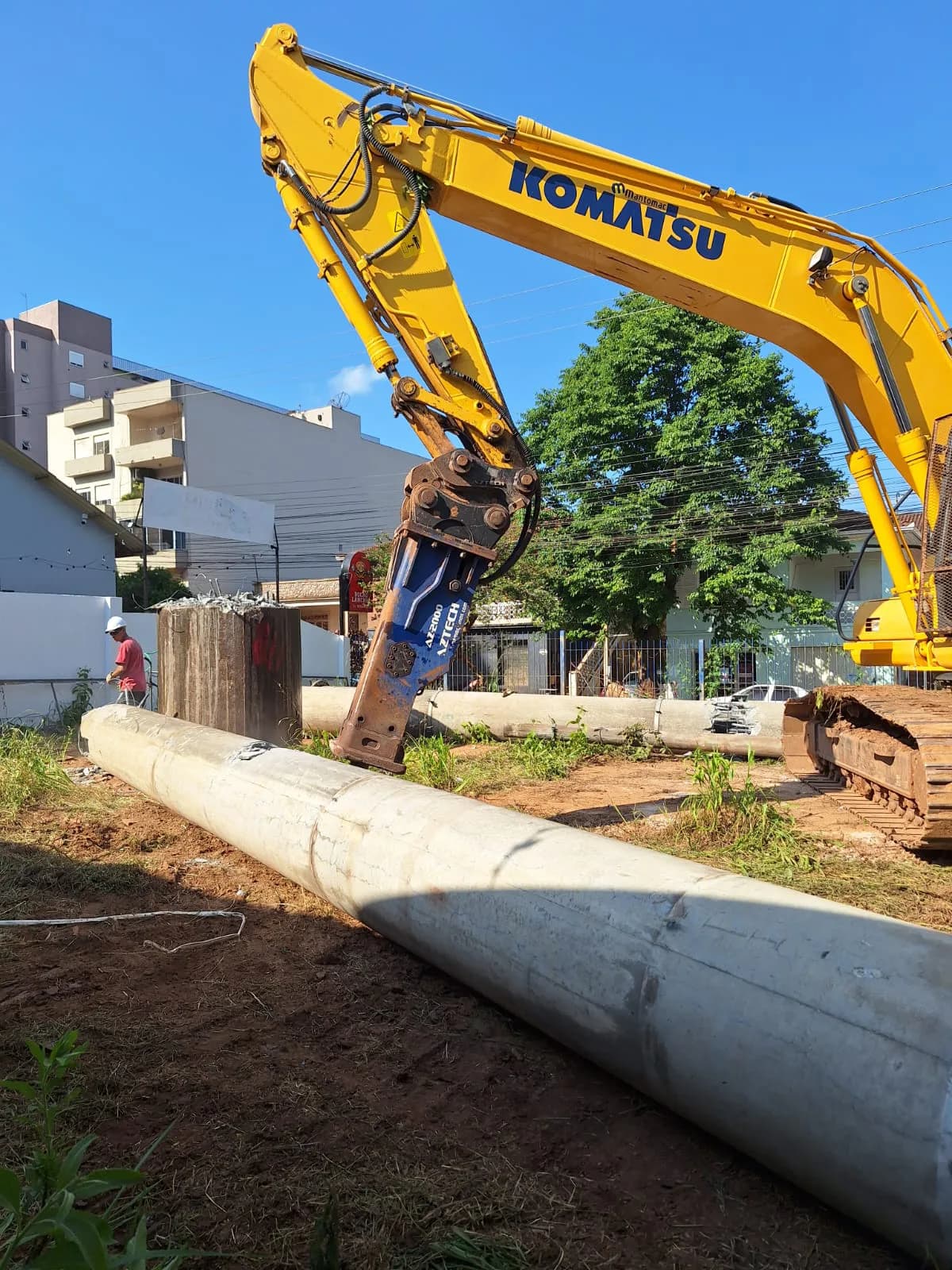 Escavadeira com rompedor atuando na retirada de poste de concreto