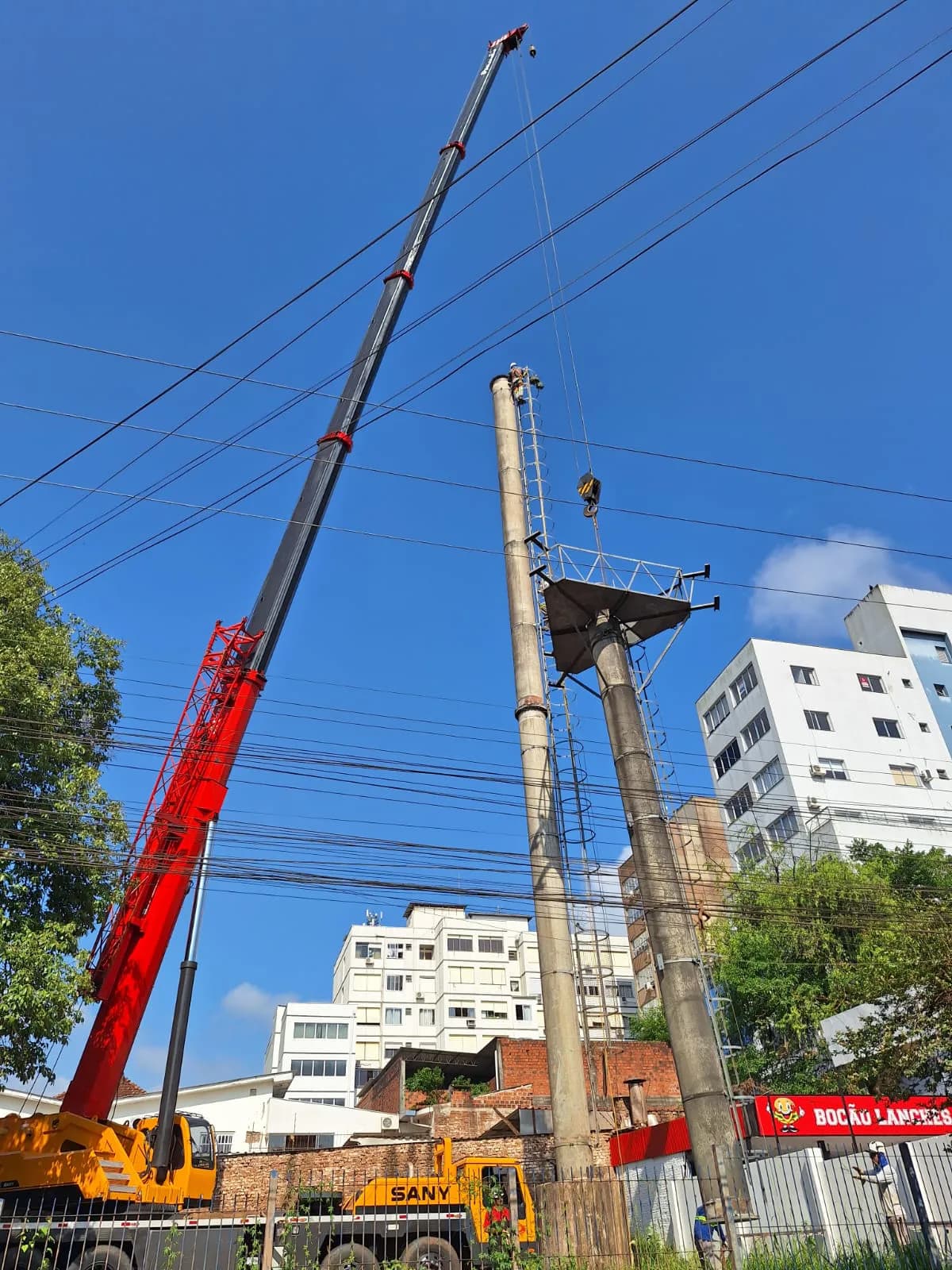 Guindaste em operação de desmontagem de estrutura em área urbana